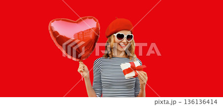 Cute portrait of happy smiling woman with red heart shaped balloon and gift box Cute portrait of happy smiling woman with red heart shaped balloon and gift box 136136414