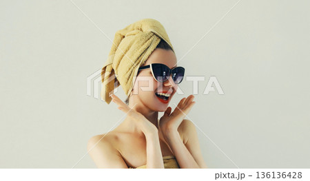 Laughing woman with wrapped towel on her head having fun in trendy sunglasses 136136428