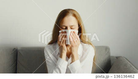 Sick exhausted young woman sneezing blow nose using tissue, unhealthy suffering girl feels unwell 136136462