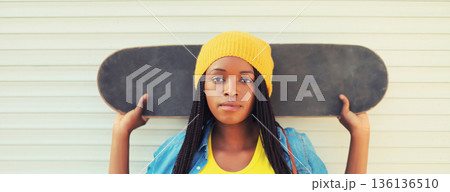 young african woman model posing with skateboard young african woman model posing with skateboard 136136510