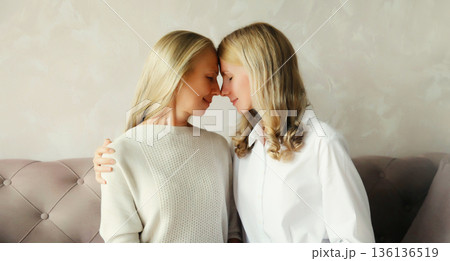 happy two women, mature mother and adult daughter together hugging at home happy two women, mature mother and adult daughter together hugging at home 136136519