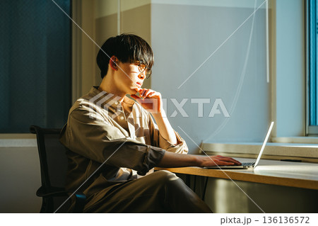 夕暮れに考え事をする若い男性 136136572