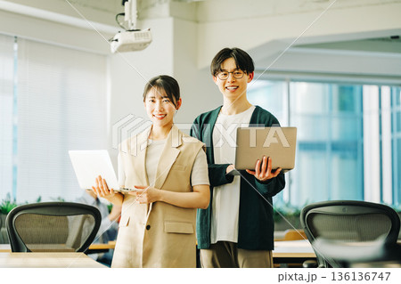 ノートパソコンを持つ若いITエンジニアの男女 136136747