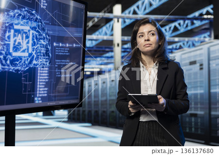 Backend equipment troubleshooting, AI projection on large display and software developer in data center. Deep learning application, tablet and employee in server farm solving system bugs 136137680