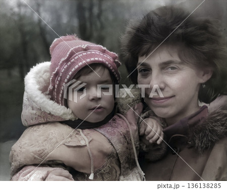 A vintage portrait of a mother and daughter on a walk. The happy mother holds her baby in her arms. Retro photo from 1995. 136138285