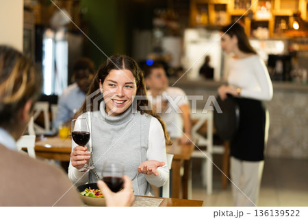 Woman talking to her husband in a restaurant Woman talking to her husband in a restaurant 136139522