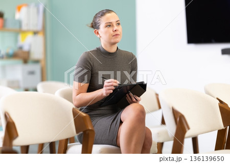 female student with a tablet in her hands listens to a lecture female student with a tablet in her hands listens to a lecture 136139650