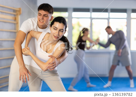 Self defense lesson - woman learns to fight back an attacking man 136139782