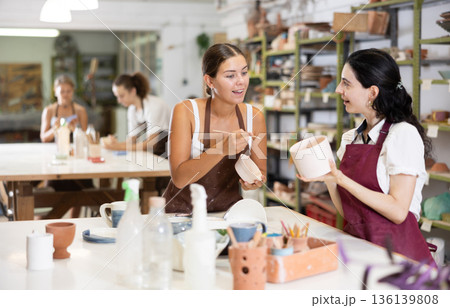 Girl performs polishing of ceramic product Girl performs polishing of ceramic product 136139808