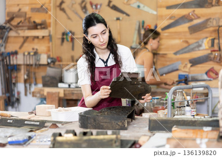 Girl is busy in carpentry workshop 136139820