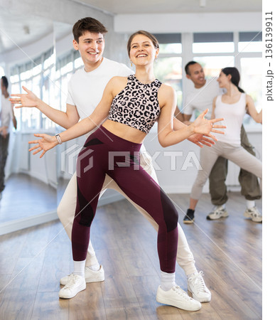 Couples of young men and women dancing twist Couples of young men and women dancing twist 136139911