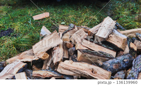Pile of firewood logs on grass, preparing for winter Pile of firewood logs on grass, preparing for winter 136139960