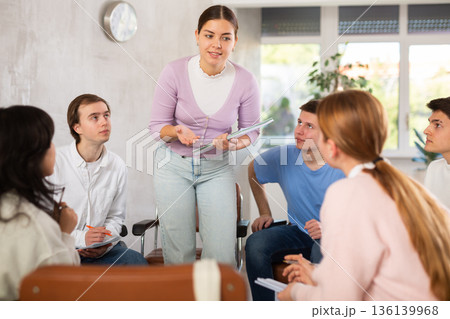 Group of students preparing for exam together in classroom of college 136139968