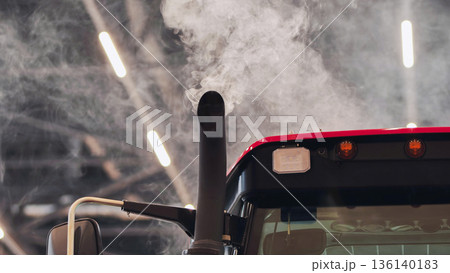 Smoke coming out of tractor exhaust pipe in agricultural fair 136140183