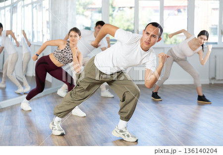 Young Asian man energizing group during dance fitness class 136140204