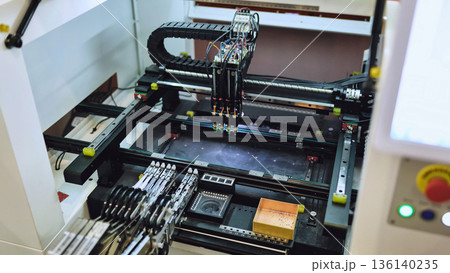 Pick and place machine assembling electronic components in SMT manufacturing facility Pick and place machine assembling electronic components in SMT manufacturing facility 136140235
