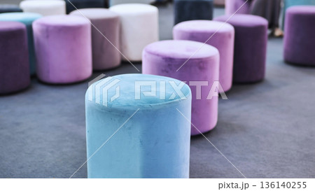 Colorful velvet poufs creating modern seating arrangement in a contemporary interior Colorful velvet poufs creating modern seating arrangement in a contemporary interior 136140255