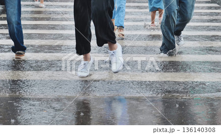 People walking on zebra crossing during rainy day, splashing water from puddles People walking on zebra crossing during rainy day, splashing water from puddles 136140308