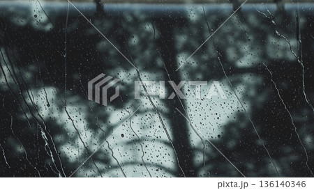 Rain droplets streaming down clear window glass on a wet, gray day Rain droplets streaming down clear window glass on a wet, gray day 136140346