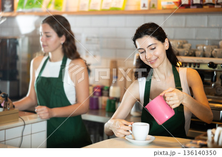 Young woman pouring coffee in cafe 136140350