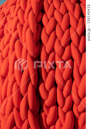 Chunky knit pattern in vibrant red yarn displaying texture and abstract design 136140418