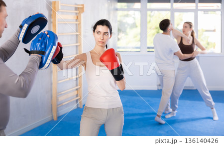 Young woman training in boxing fight in studio 136140426