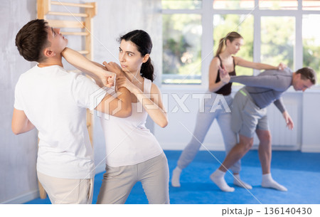 Young woman and guy training self-defense techniques 136140430