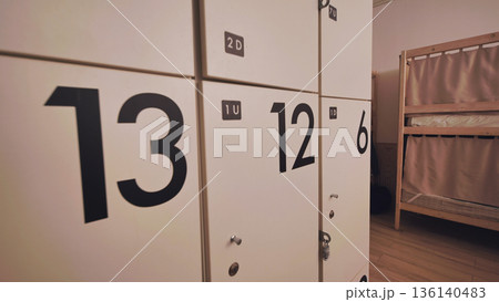 Hostel dormitory with numbered storage lockers and bunk beds for travelers 136140483