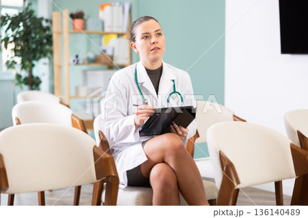 Young woman medical student takes notes on tablet Young woman medical student takes notes on tablet 136140489