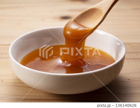 木のスプーンですくった濃厚なマヌカハニー（白バック・クローズアップ） 136140626