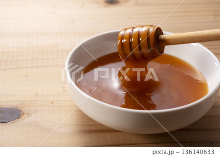 ハニーディッパーから垂れる濃厚なマヌカハニー（白バック・クローズアップ） 136140633