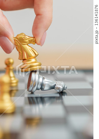 hand moving gold Chess King figure and Checkmate opponent during chessboard competition. Strategy, Success, management, business planning, win, disruption, Trade war and leadership concept 136141876