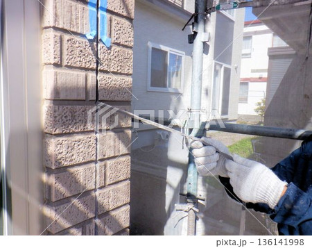 外壁サイディングの古いシーリングを撤去する作業風景 136141998