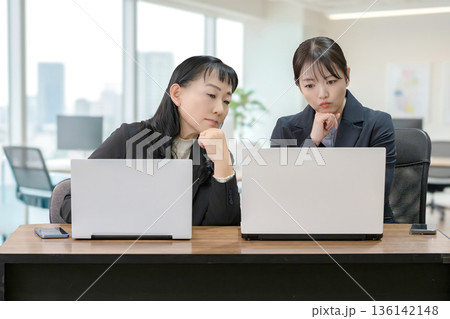 パソコンと考える二人のビジネスウーマン 136142148