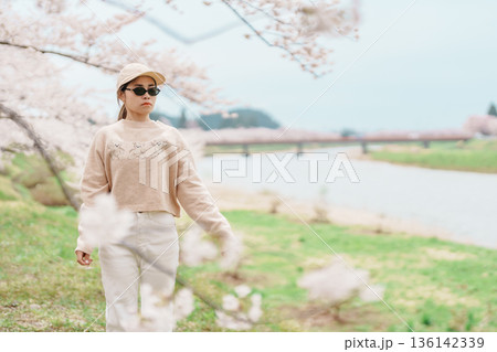 Woman tourist sightseeing Sakura Cherry Blossom in Spring. Happy traveler travel near Hinokinai River riverbank in Kakunodate town, Semboku District, Akita Prefecture, Japan. Landmark and Vacation Woman tourist sightseeing Sakura Cherry Blossom in Spring. Happy traveler travel near Hinokinai River riverbank in Kakunodate town, Semboku District, Akita Prefecture, Japan. Landmark and Vacation 136142339