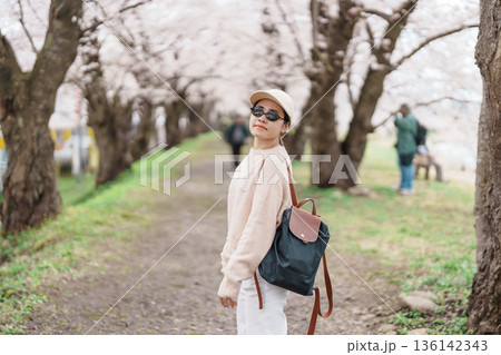 Woman tourist sightseeing Sakura Cherry Blossom in Spring. Happy traveler travel near Hinokinai River riverbank in Kakunodate town, Semboku District, Akita Prefecture, Japan. Landmark and Vacation Woman tourist sightseeing Sakura Cherry Blossom in Spring. Happy traveler travel near Hinokinai River riverbank in Kakunodate town, Semboku District, Akita Prefecture, Japan. Landmark and Vacation 136142343