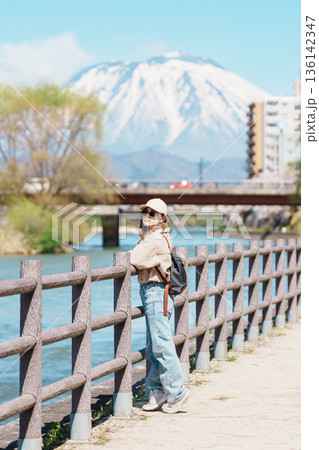 Woman tourist sightseeing Iwate mountain and Kitakami river with flowers in Spring, happy traveler travel in Morioka city, Iwate prefecture, Japan. famous Landmark Travel and Vacation destination Woman tourist sightseeing Iwate mountain and Kitakami river with flowers in Spring, happy traveler travel in Morioka city, Iwate prefecture, Japan. famous Landmark Travel and Vacation destination 136142347
