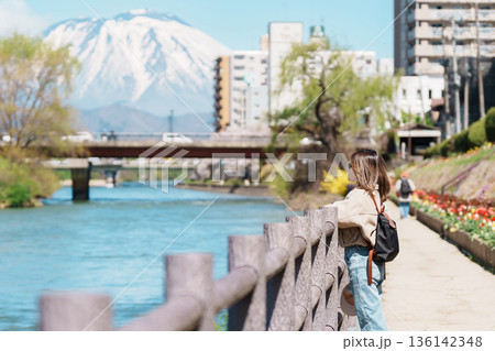 Woman tourist sightseeing Iwate mountain and Kitakami river with flowers in Spring, happy traveler travel in Morioka city, Iwate prefecture, Japan. famous Landmark Travel and Vacation destination Woman tourist sightseeing Iwate mountain and Kitakami river with flowers in Spring, happy traveler travel in Morioka city, Iwate prefecture, Japan. famous Landmark Travel and Vacation destination 136142348
