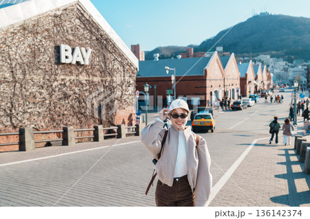 Woman tourist Visiting in Hakodate, happy Traveler sightseeing Kanemori Red Brick Warehouse in spring season. landmark and popular for attractions in Hokkaido, Japan. Travel and Vacation concept 136142374