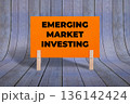 Concept words Emerging Market Investing, Orange Rectangle Card Held By Clothespin Wooden Texture Background, Business and Emerging Market Investing Theme 136142424