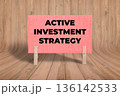 Concept words Active Investment Strategy, Light Pink Grunge Texture Rectangle Card Held By Clothespin Wooden Texture Background, Business and Active Investment Strategy Theme 136142533