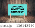 Concept words Dividend Investing Strategy, Aquamarine Concrete Texture Rectangle Card Held By Clothespin Wooden Texture Background, Business and Dividend Investing Strategy Theme 136142540