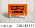 Concept words Emotional Investing Dangers, Orange Concrete Texture Rectangle Card Held By Clothespin Wooden Texture Background, Business and Emotional Investing Dangers Theme 136142542