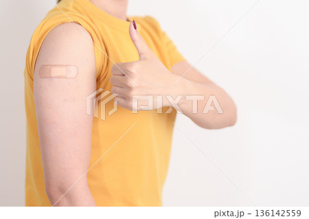 Adult Woman with bandage after received vaccine. Vaccination and Immunization for Influenza, HPV, Zoster, IPD, DTP or Diphtheria, Tetanus and Pertussis, MMR, Hepatitis B, Covid and Nipha virus vaccine 136142559