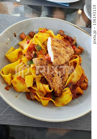 Interlaken, Switzerland - March 17 2023: Pappardelle with chicken at Restaurant Crystal Jungfraujoch Interlaken, Switzerland - March 17 2023: Pappardelle with chicken at Restaurant Crystal Jungfraujoch 136143119