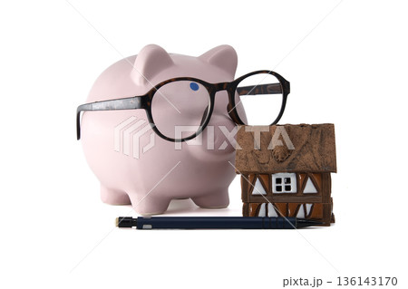 Smart piggy bank with glasses and miniature house, symbolizing financial planning and home savings Smart piggy bank with glasses and miniature house, symbolizing financial planning and home savings 136143170