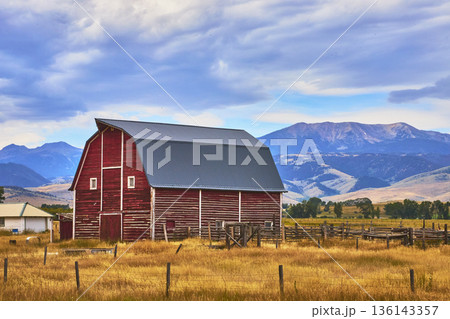 Red Barn With Wyoming Mountain Landscape And Rural Prairie Under Dramatic Sky 136143357