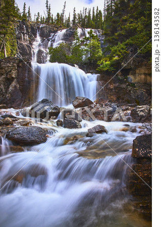 Tangle Falls Waterfall Flowing Over Rocks With Evergreen Trees In Jasper Canada Tangle Falls Waterfall Flowing Over Rocks With Evergreen Trees In Jasper Canada 136143582