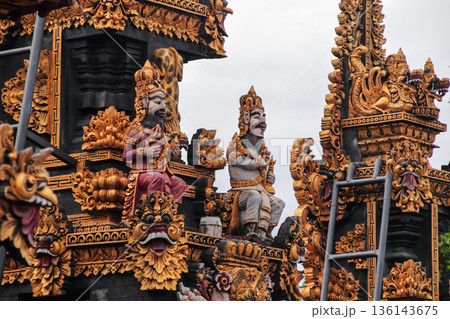 Ornate Balinese temple carvings with intricate gold leaf details for cultural tourism concept 136143675