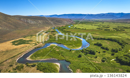 Aerial Meandering River Green Fields and Mountain Landscape Near Cokeville Wyoming 136143824